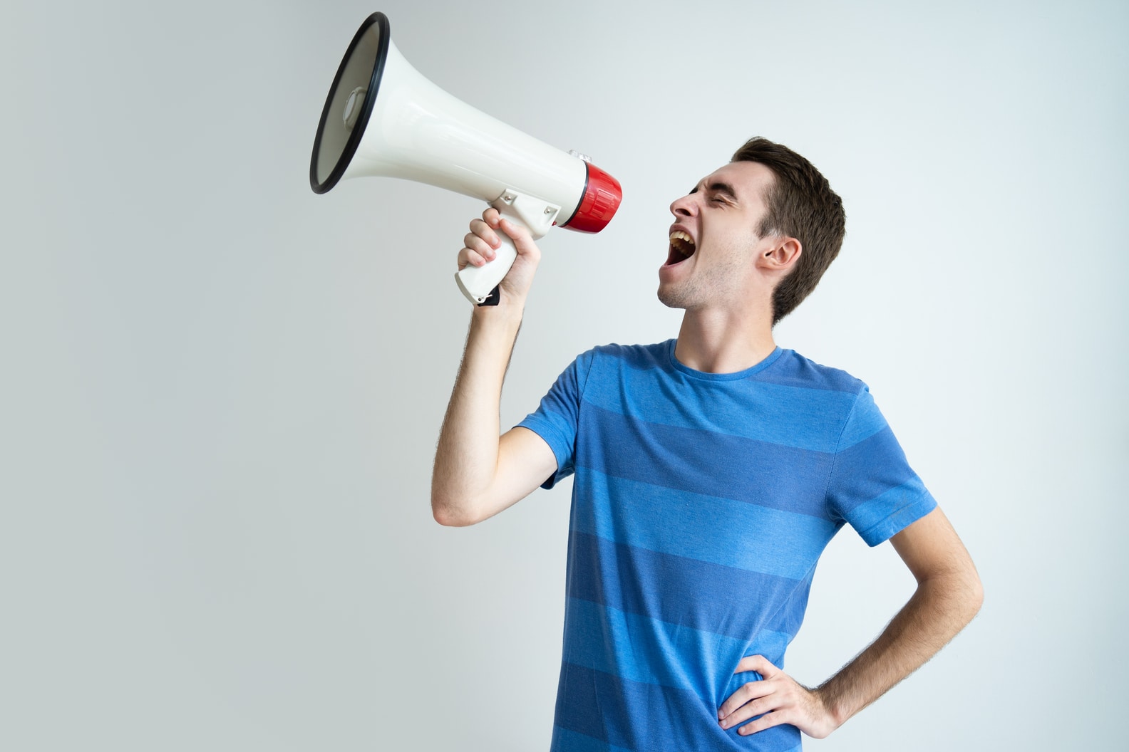 A imagem mostra um homem de camiseta azul segurando um megafone, fazendo sua voz de consumidor ser ouvida.
